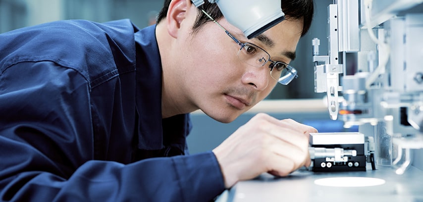Male worker closely inspecting electronics